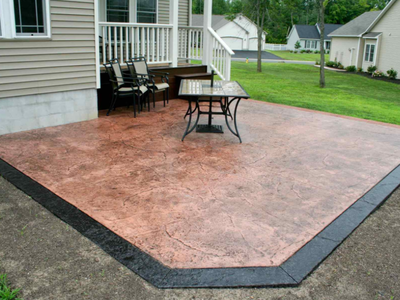 A brown stamped patio, with a dark brown concrete edging.