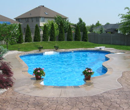 Textured concrete edged pool deck with stone design around edging.