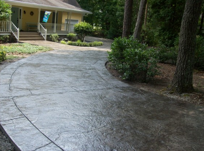 Stained dark and textured concrete driveway.