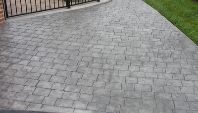 Gray stone patterned stamped concrete driveway.