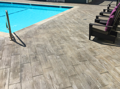 Wood plank designed stamped concrete pool deck.
