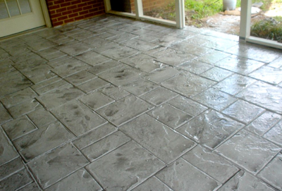 Polished and stamped gray concrete indoor patio.