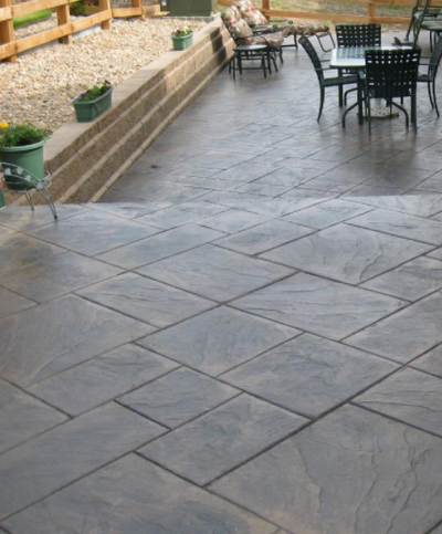 Mixed brown stained and stamped concrete patio with stairs.
